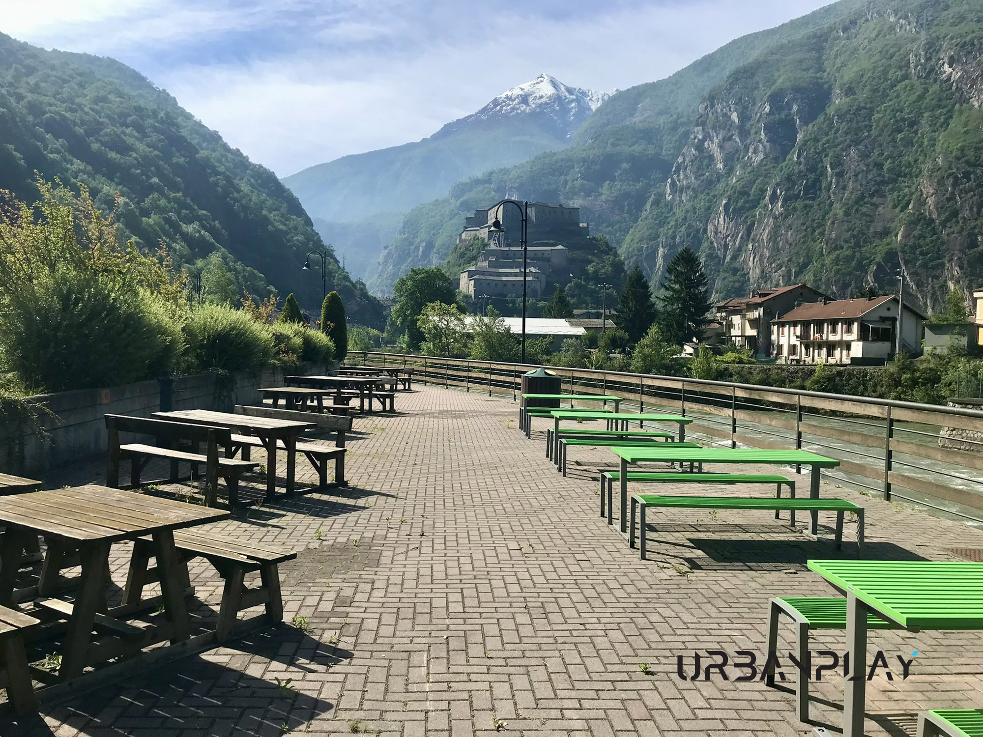 RiquRiqualificazione area Liéron Bard con tavoli e panche verdi e Forte di Bard sullo sfondo