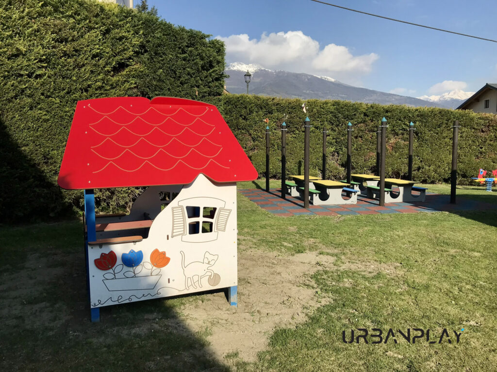 Casetta gioco nel giardino della scuola materna di Pollein con attrezzature sullo sfondo