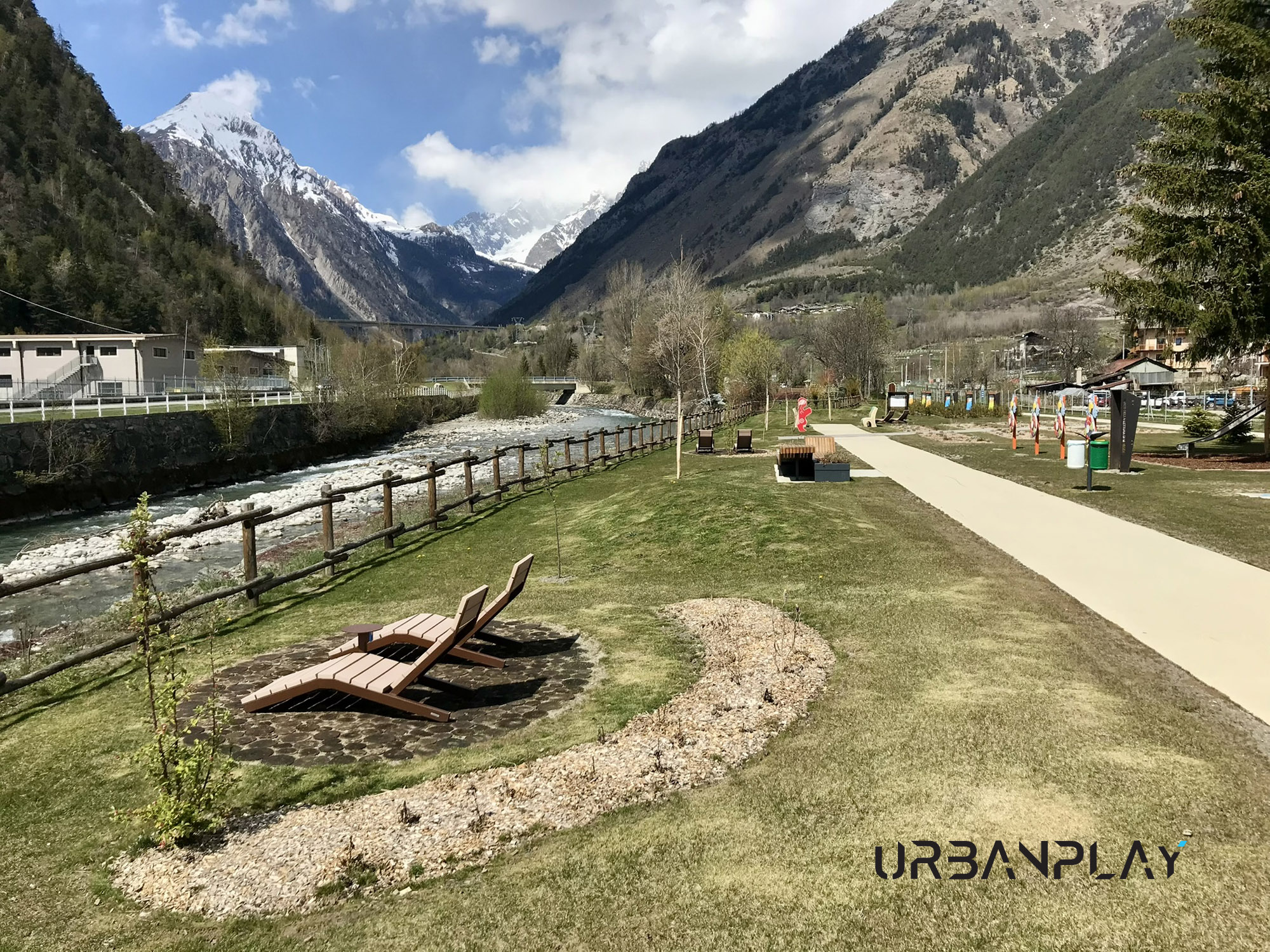 Parco della Lettura Morgex con chaise longue, percorso pedonale e paesaggio alpino
