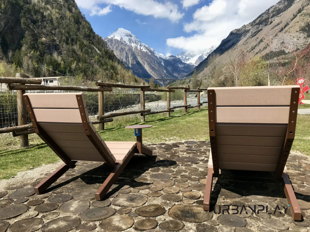 Vista posteriore di due chaise longue in Resysta con tavolino e panorama montano