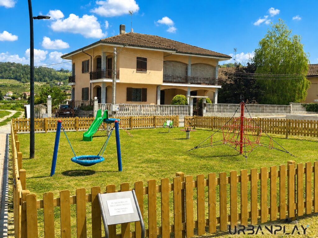 Area giochi recintata del parco giochi Motta con attrezzature ludiche su prato