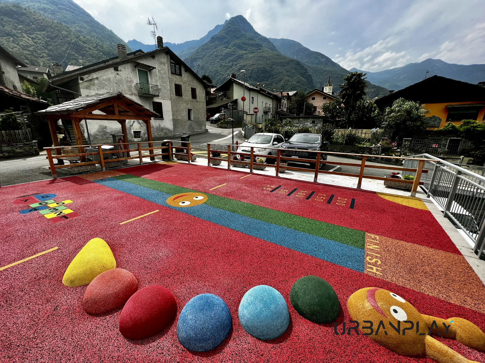 Parco giochi Pied de Ville a Issogne con pavimentazione antitrauma colorata e forme tridimensionali