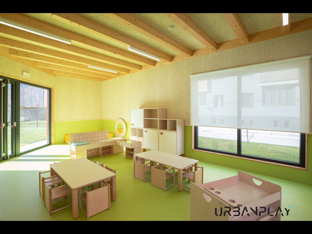 Aula luminosa con tavoli, seggioline e mobili bassi per le attività dei bambini