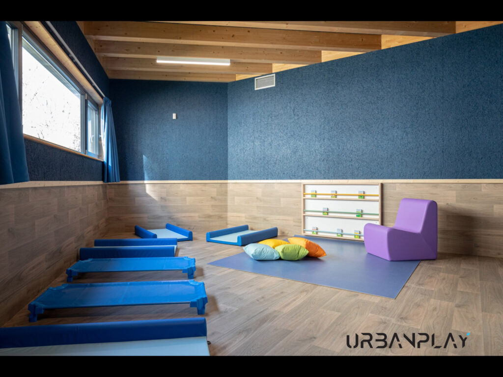 Sala per il riposo con lettini bassi, tappeto, cuscini e libreria frontale