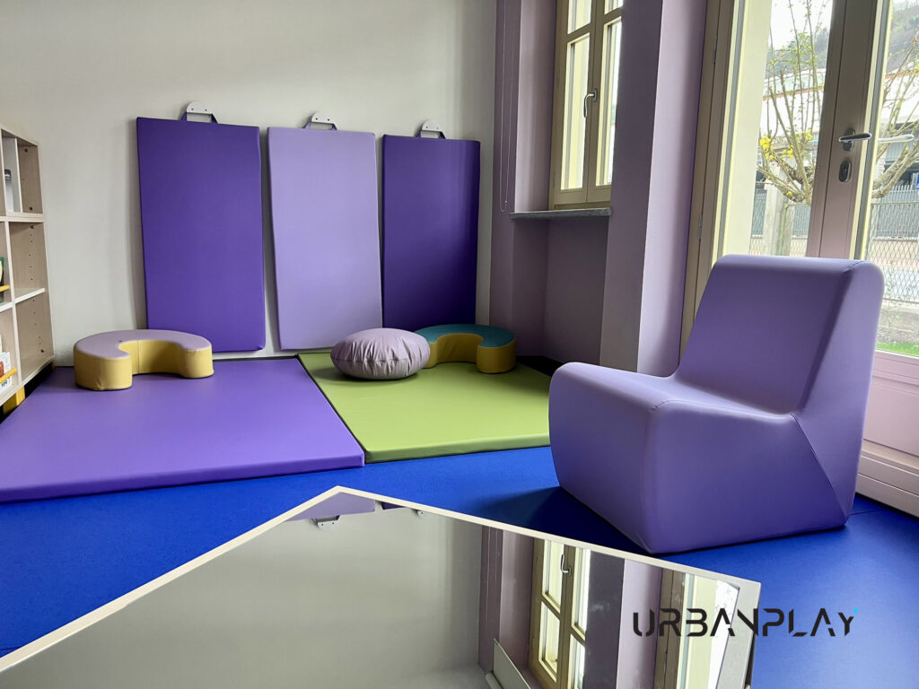 Spazio morbido con tappeti, specchi e poltrona per bambini