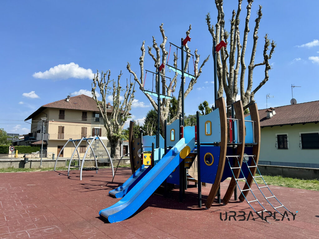 Struttura gioco a tema nave con scivolo blu e altalena sullo sfondo