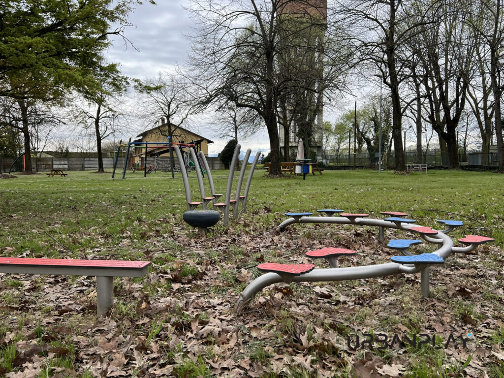Struttura gioco dinamica con montanti curvi e attrezzature distribuite nell’area verde