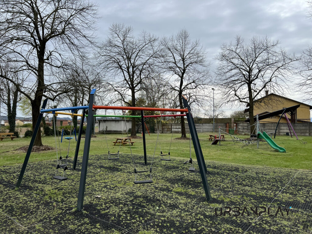 Altalena a cestone blu con giochi inclusivi e area attrezzata sullo sfondo