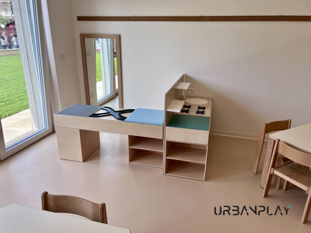 Area gioco simbolico con mobile fasciatoio, cucina gioco, specchio e tavolini