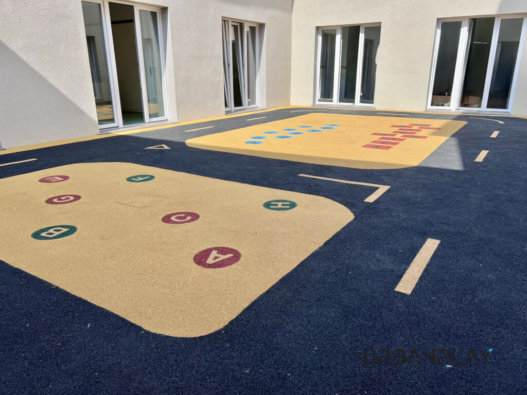 Spazio esterno protetto con pista grafica, lettere e numeri inseriti nella pavimentazione