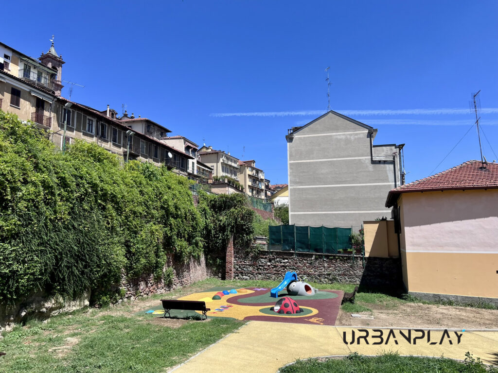 Vista generale dell’area giochi con pavimentazione colorata e giochi tridimensionali