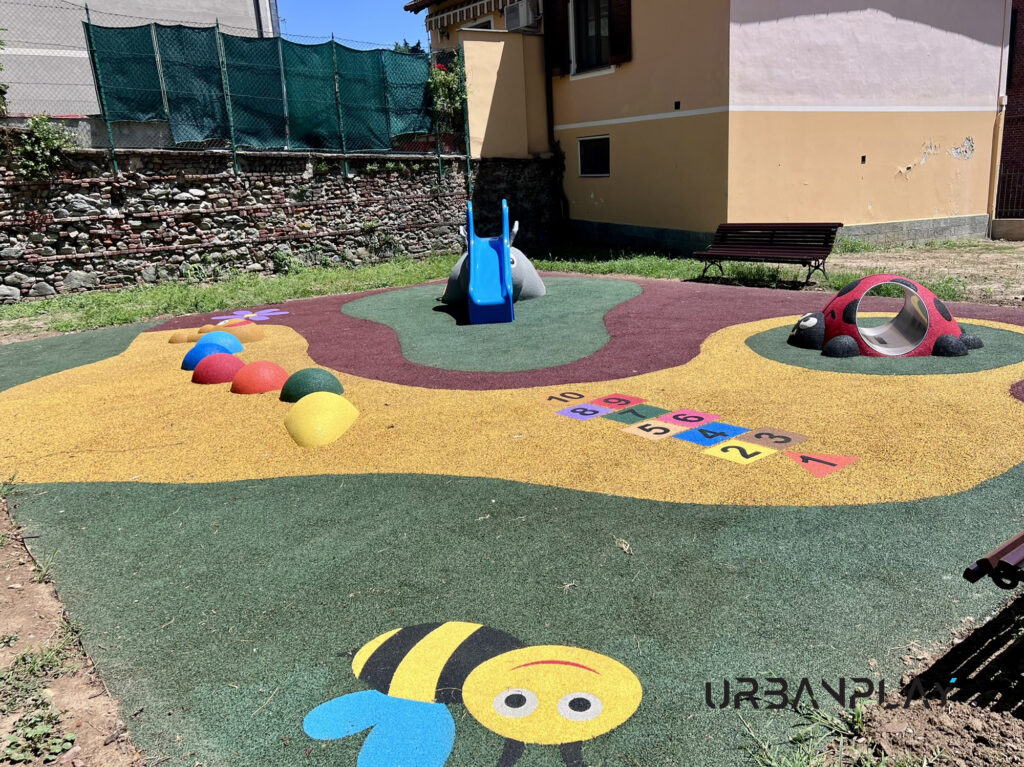 Pavimentazione ludica con ape, campana e giochi per bambini nel Giardino Incantato di Moncalieri