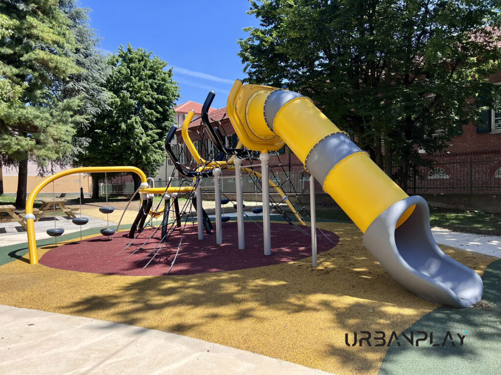 Scivolo tubolare giallo con percorso di arrampicata e sedute sospese nell’area gioco