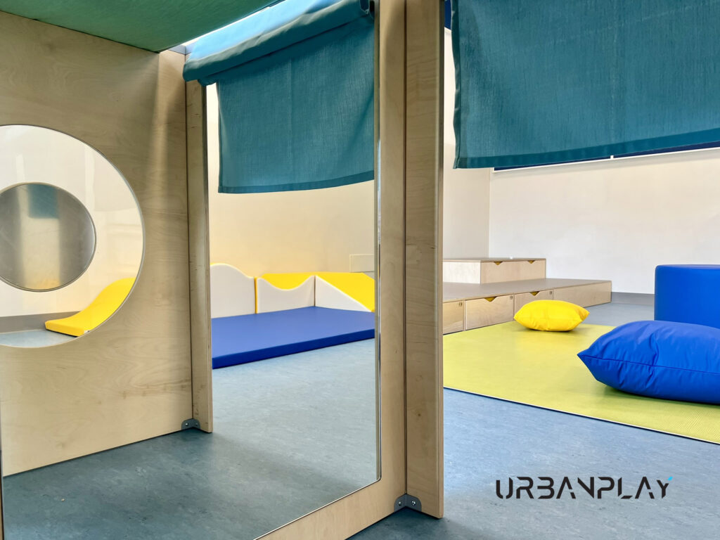 Struttura gioco interna con specchio, tenda e area morbida per bambini nel nido di Val di Chy