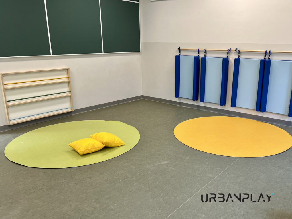 Sala per attività motorie con tappeti, cuscini e protezioni morbide nell’asilo nido di Val di Chy
