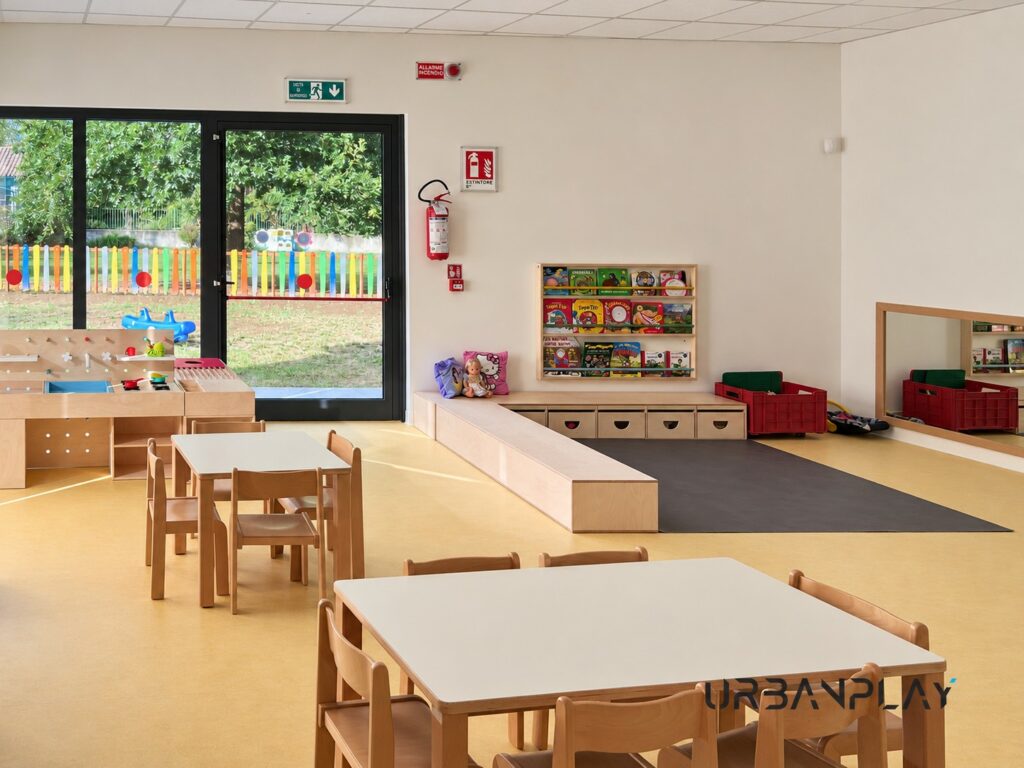 Libreria per bambini, panche contenitore e specchio nella Scuola dell’Infanzia Collodi
