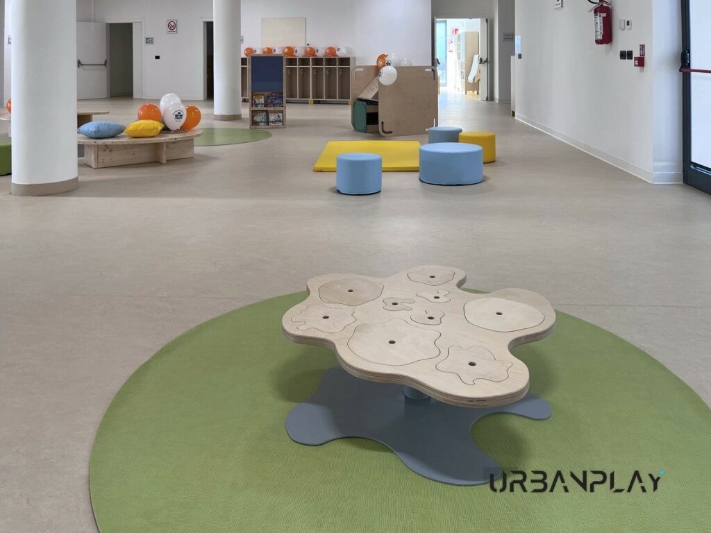 Spazio comune del Polo dell’Infanzia di Ciriè con tavolo sagomato e sedute morbide